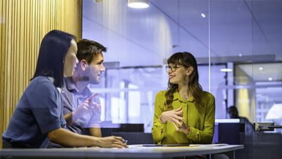 a group of business people sitting at a table talking