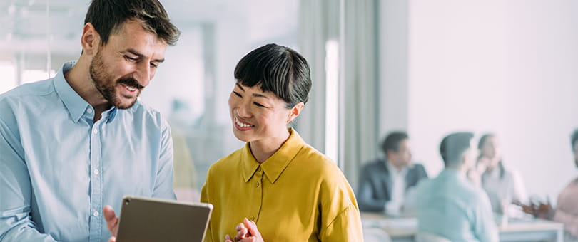a man and a woman looking at a laptop