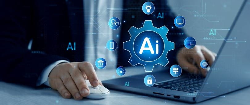 Man's hand on mouse next to laptop