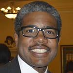 Alan Henderson Picture, a man with curly hair and glasses.