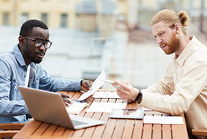 a couple of men looking at a laptop