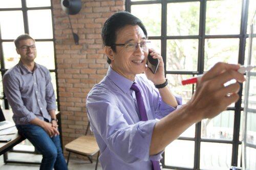 Older asian businessman on mobile for blog post