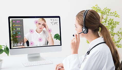 a doctor wearing headphones looking at a computer screen a doctor wearing headphones looking at a computer screen