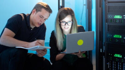 a man and a woman looking at a laptop