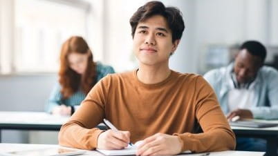 A smiling man student in a classroom