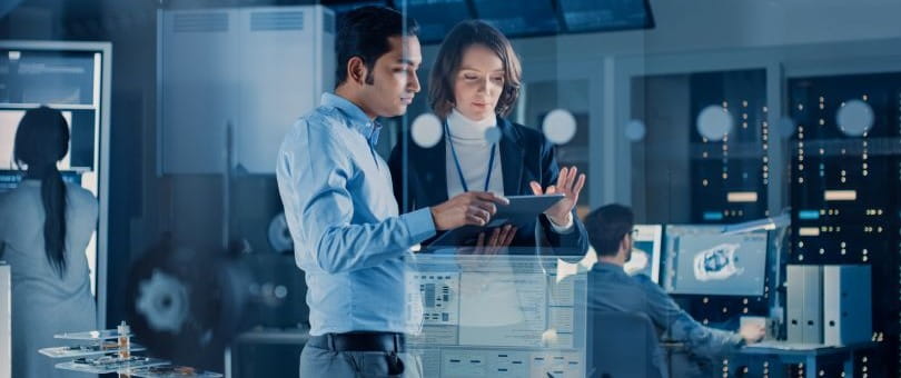 A man and a woman looking at a computer screen
