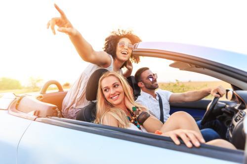 Three happy people riding in convertible for blog post