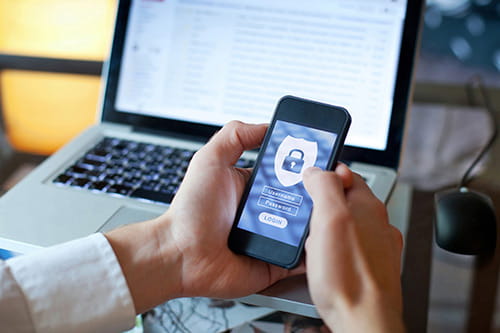 Man holding phone with cyber-security app for blog