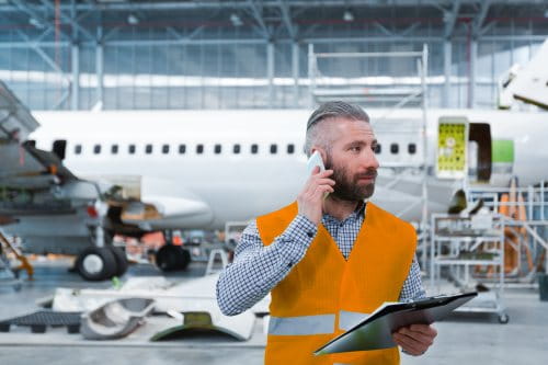 Man talking on mobile in an airplane hangar for blog post