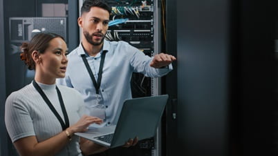 a man and a woman looking at a laptop