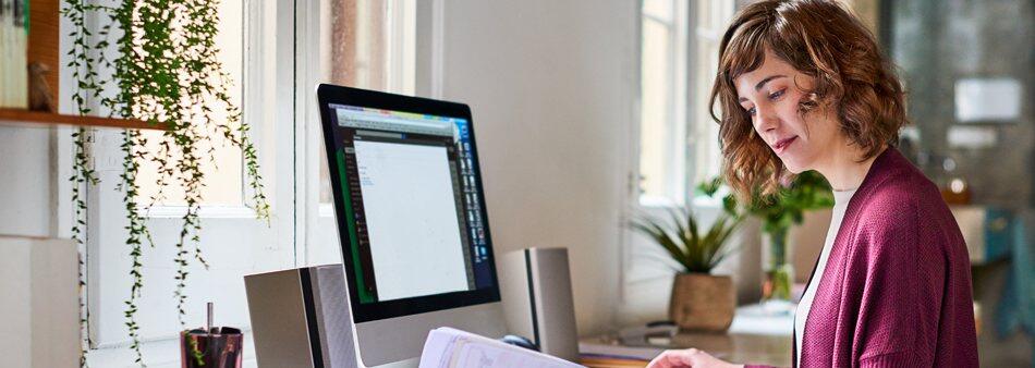 a person sitting at a desk in front of a window a person sitting at a desk in front of a window