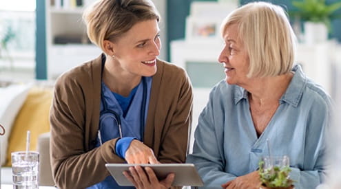 Two women working on a tablet.