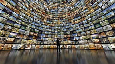 Room full of monitors with a man standing in the middle Room full of monitors with a man standing in the middle