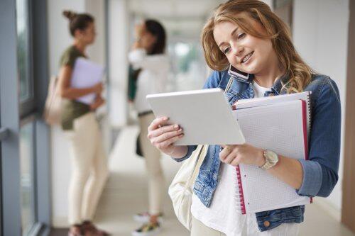 Female student on mobile phone looking at tablet