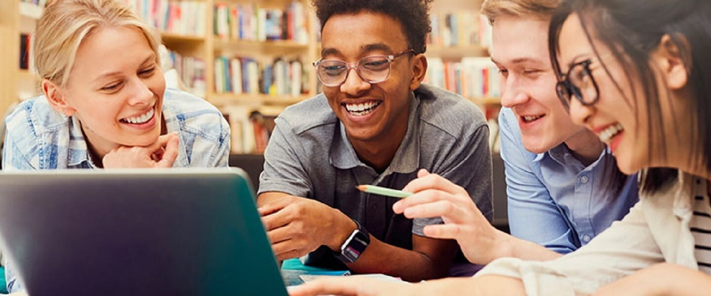 A group of students looking at a laptop