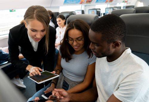 Train passengers and conductor on tablet for blog post