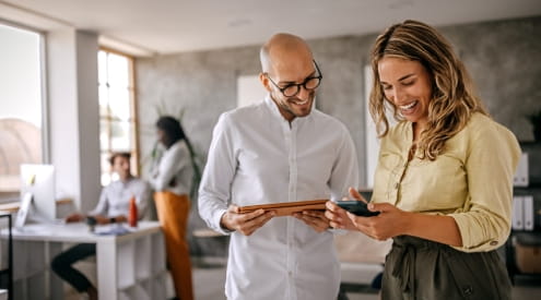 Man and woman looking at devices